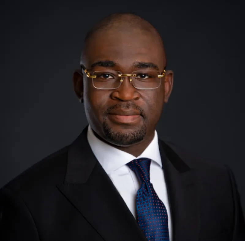 Portrait de Zoumana Coulibaly, en costume sombre et lunettes.